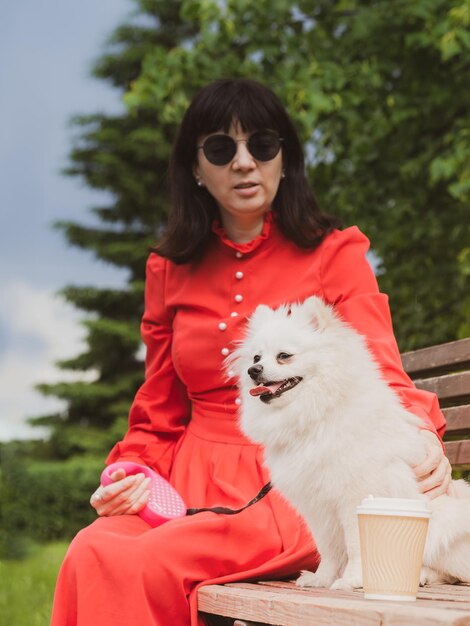 Closeup woman dog and paper cup of coffee on a park bench