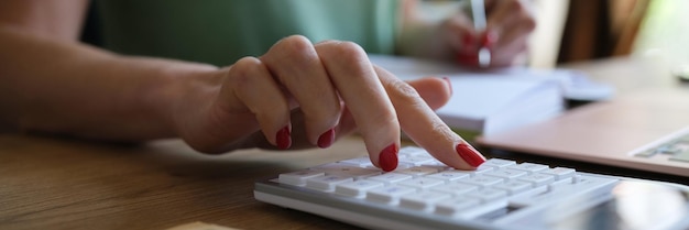 Closeup of woman doing calculation of expenses and income and making notes project