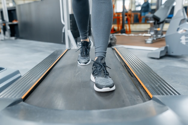 Closeup of woman feet running on treadmill in gym