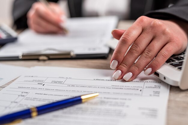 closeup woman filling 1040 tax form at office deadline accounting concept