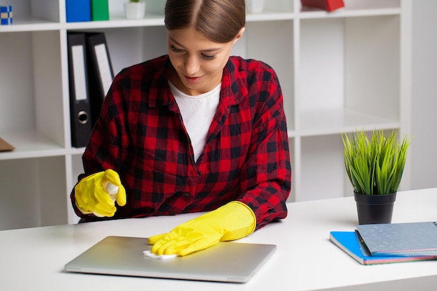 オフィスでラップトップを掃除する女性の手のクローズ アップ