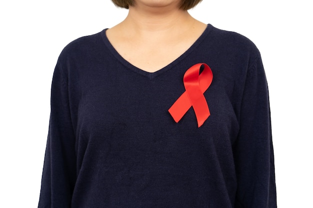 Closeup woman hand holding red ribbon HIV