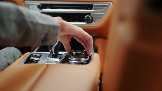 closeup woman hand using control knob in car female using car joystick