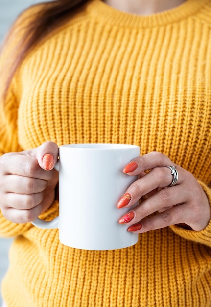 Closeup woman hands holding white mug for mockup design