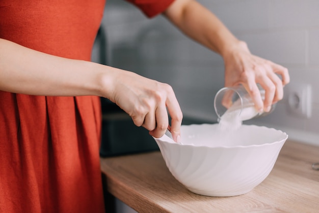 キッチンで食事を準備する女性の手のクローズアップ