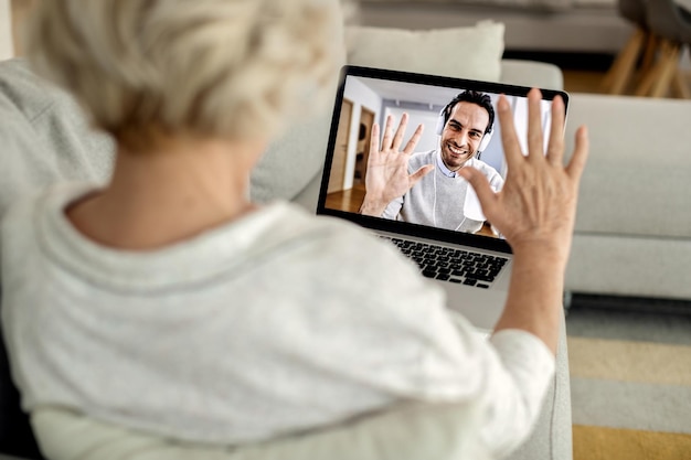 Closeup of woman having video call with her adult son over laptop