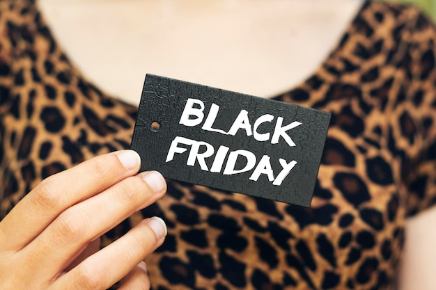 closeup woman holding black friday sale tag concept