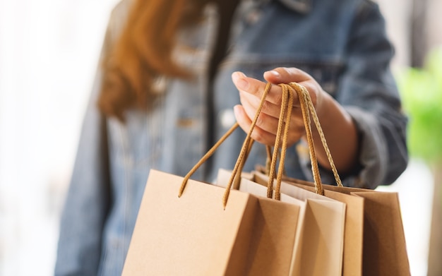 Closeup  of a woman holding and showing shopping bags