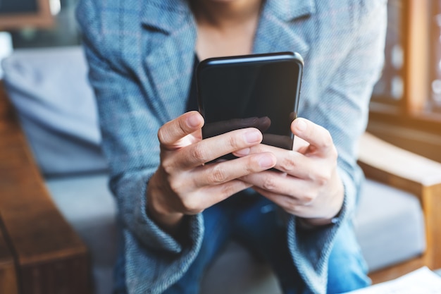 Closeup  of a woman holding and using mobile phone