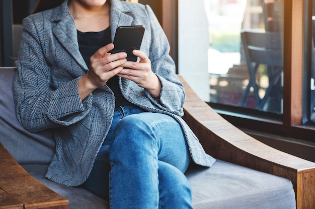 Closeup  of a woman holding and using mobile phone