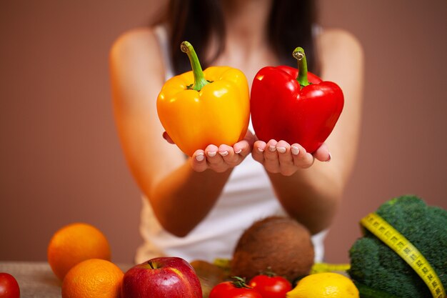 Closeup of woman holding yellow and red peppers in her hands