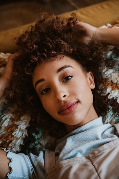 Closeup of a woman lying on a mustard yellow couch