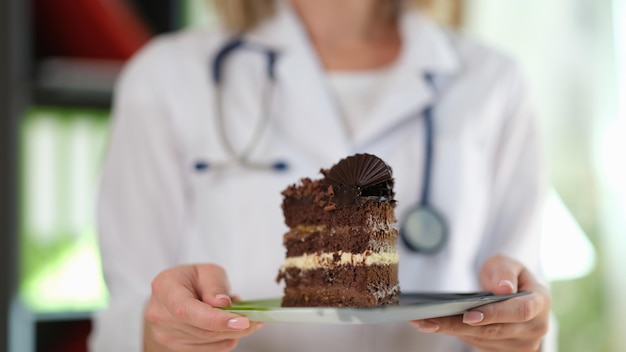 Closeup of woman nutritionist holding in hands piece of chocolate cake healthy food diet