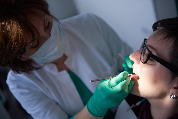 Closeup of a woman patient at the dentist waiting to be checked up with the woman doctor in the background