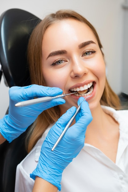 Photo closeup woman patient sitting in armchair during dental treatment in dental clinic doctor checking