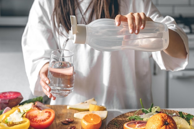 グラスに水を注ぐ女性の接写