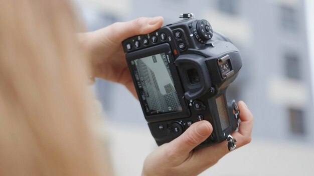 Closeup of woman and professional camera screen action female photographer shoots residential