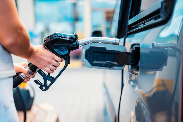 Closeup of woman pumping gasoline fuel in car at gas station Petrol or gasoline being pumped into a motor Transport concept