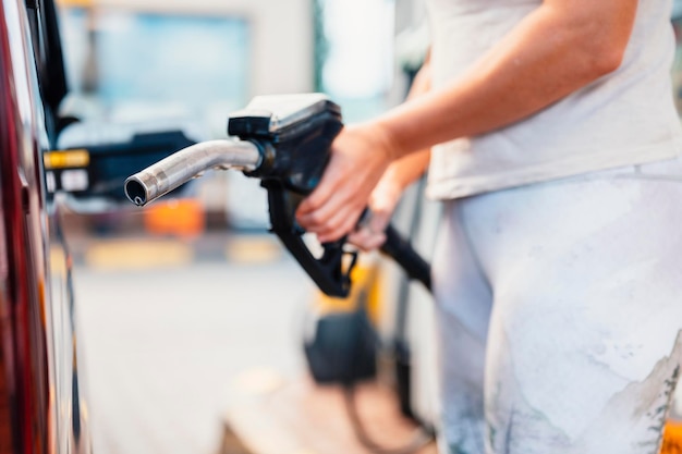 Closeup of woman pumping gasoline fuel in car at gas station Petrol or gasoline being pumped into a motor Transport concept