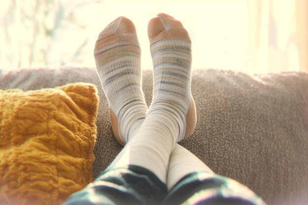 Closeup woman relaxes on sofa in white striped socks