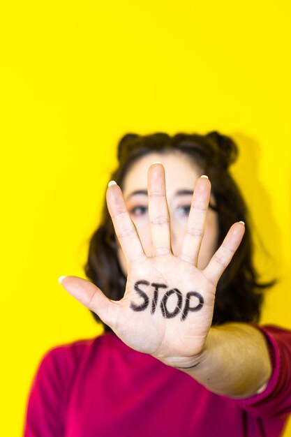 Close-up della mano di una donna con la parola stop scritta su di essa concetto di lotta e uguaglianza dei diritti delle donne giornata della donna