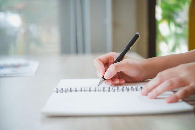 Primo piano della mano della donna che scrive sul libro