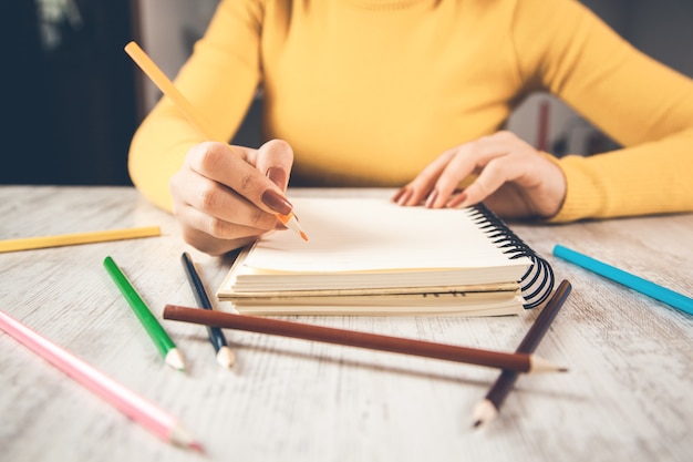 Primo piano della mano della donna che scrive su carta