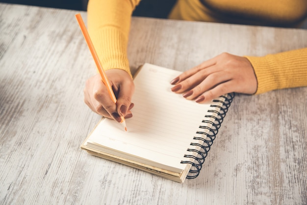 Primo piano della mano della donna che scrive su carta