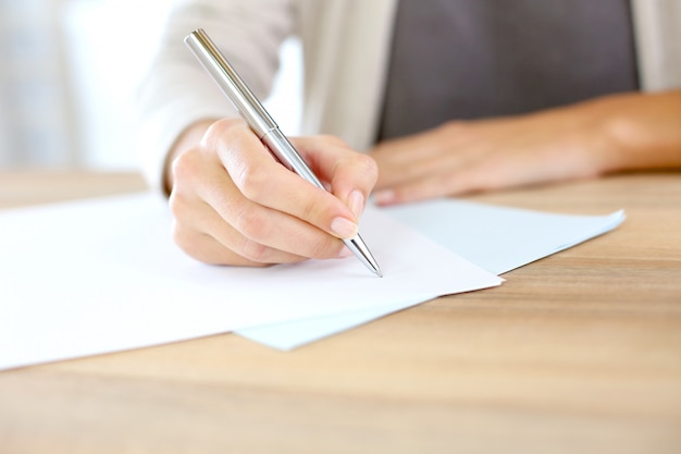 Closeup of woman's hand writing on paper