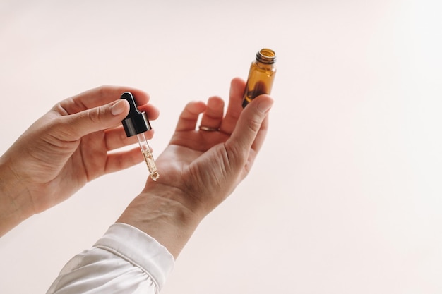 Closeup of a Woman's hands applying essential oil on her wrist indoors