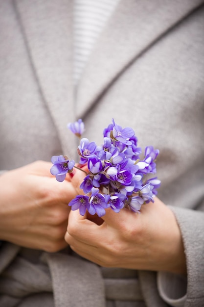 女の子の手に新鮮な野生のスノードロップ春の花の束を保持している女性の手のクローズアップ