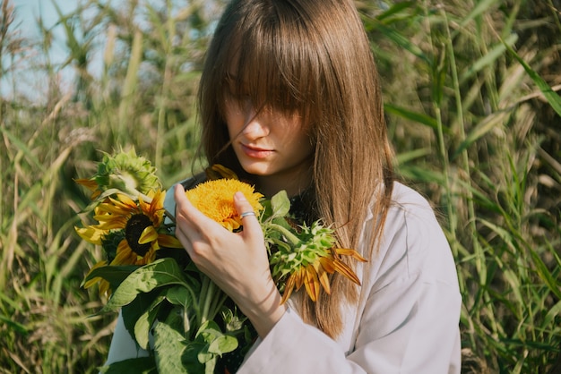 Closeup of woman's hands holding sunflowers outdoors