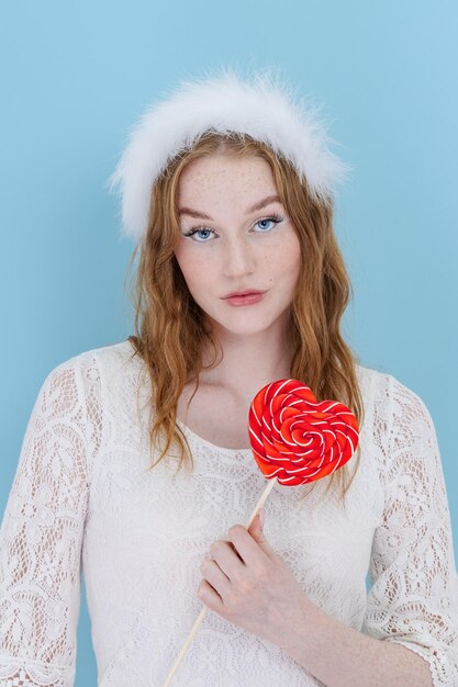 Photo closeup of woman's holding a heart lolipop in front of her