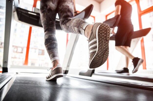 Closeup of a woman's legs running on a treadmill.