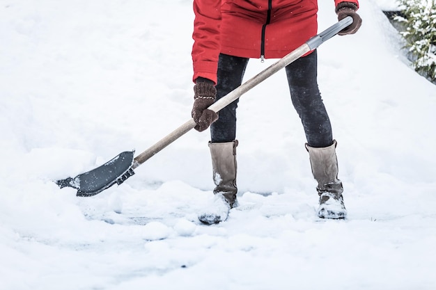 Closeup of Woman Shoveling her Parking lot