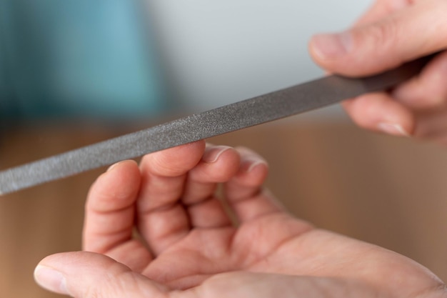 Closeup of woman undergoing nail filing in professional manicure