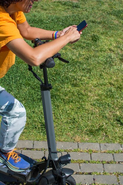 Closeup Of A Woman Using Her Smartphone To Pay And Unlock On Electric Scooter On A City Park