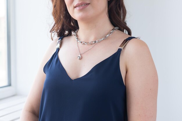 Closeup woman wearing luxury pendant and silver chain jewellery and accessories concept