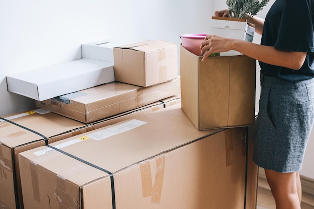 Photo closeup of a woman with carton boxes moving into new home