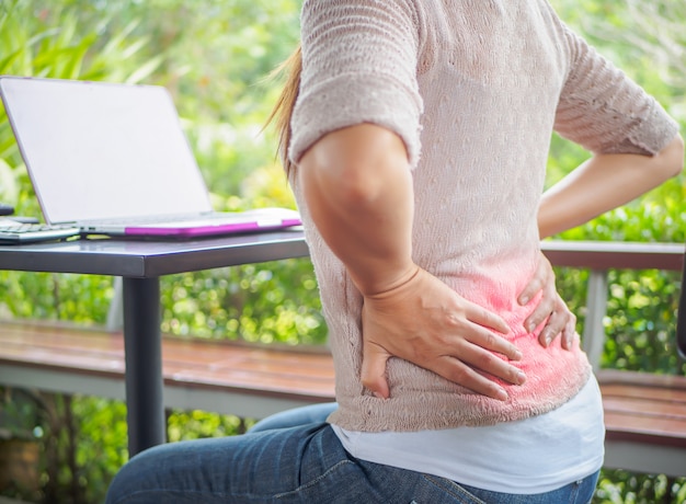 Closeup woman with hands holding her back pain. Office syndrome and Health-care Concept.