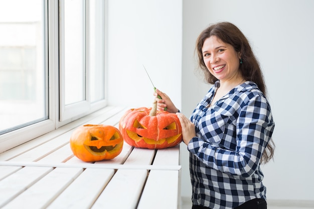 Крупным планом женщина с тыквами готовится к хэллоуину