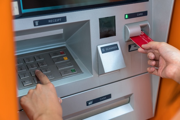 Макрофотография женщина, снимая наличные деньги через банкомат, бизнес