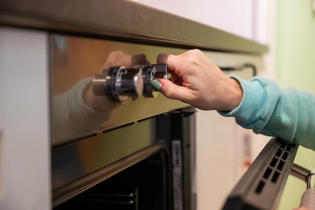 Closeup of woman39s hands open the oven Housewife includes a builtin oven unrecognizable girl is cooking pastries