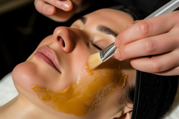 Closeup of a womans face therapist applying an organic peeloff mask