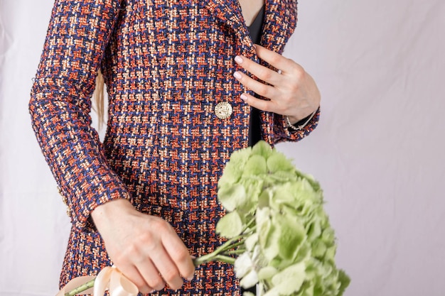 Closeup of womans hand on tweed jacket holding