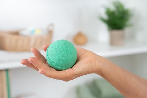 Closeup of a womans hand with soap ball in the bathroom for skin and body care cosmetic concept