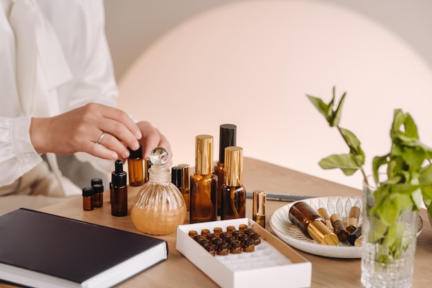 Closeup of a womans hands applying essential oil on her wrist indoors