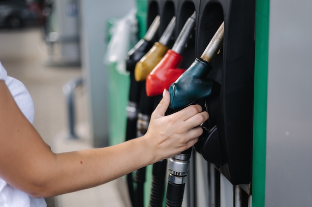 Closeup of a womens hand using a fuel nozzle at a gas station petrol station concept filling station