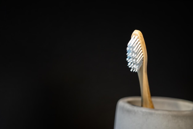 Closeup to Wood Toothbrush in the mug and in front of black background