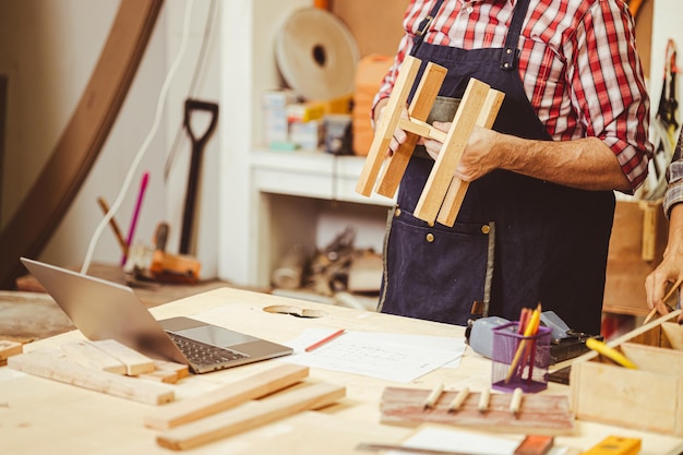 Foto carpentiere del falegname del primo piano che lavora facendo il lavoro fatto a mano della mobilia di legno diy del mestiere